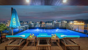 A rooftop pool area with lounge chairs and a view of the city skyline. - Sana Danang Beach Hotel (Da Nang)
