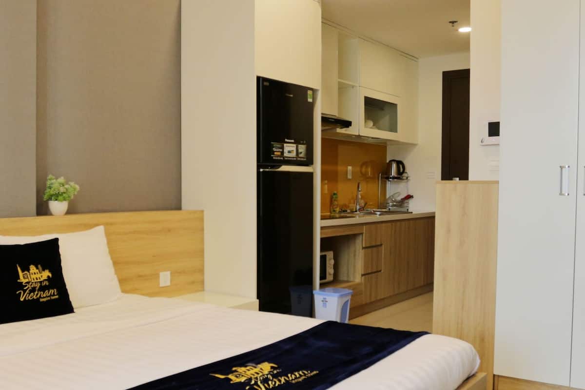 Ein Hotelzimmer mit einem Bett, einer kleinen Küchenzeile und einem Kleiderschrank.