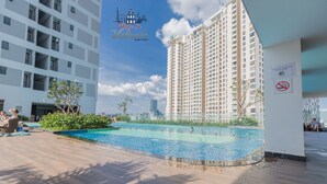 A rooftop pool area with a clear view of a high-rise building in the background. - Stay In Vietnam River Gate (Ho Chi Minh City)