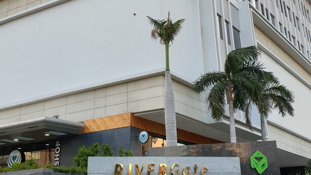 A modern building with a sign reading "RIVERGate RESIDENCE" and a logo above it. - Stay In Vietnam River Gate (Ho Chi Minh City)