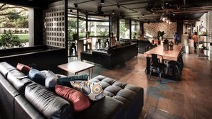 Ein modernes Interieur mit einer Ledersofa, einem Essbereich und großen Fenstern mit Blick ins Freie.