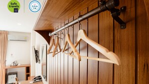 Eine Holzwand mit einem Kleiderhaken und einem daran befestigten Fernseher.