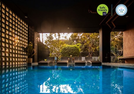 Una piscina techada, sillones reclinables de piscina