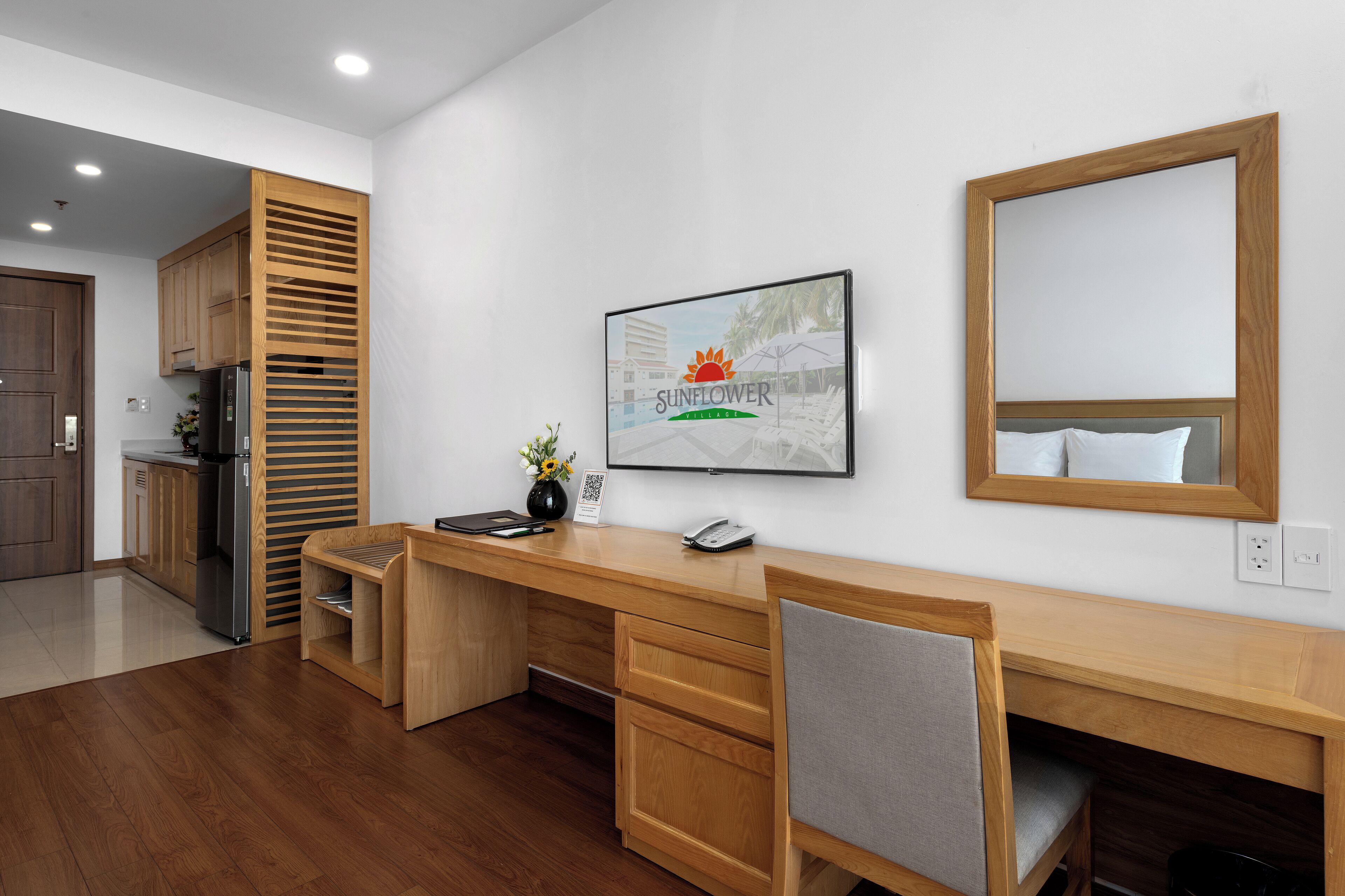 A modern kitchen with wooden cabinets, a built-in refrigerator, and a wooden dining table.