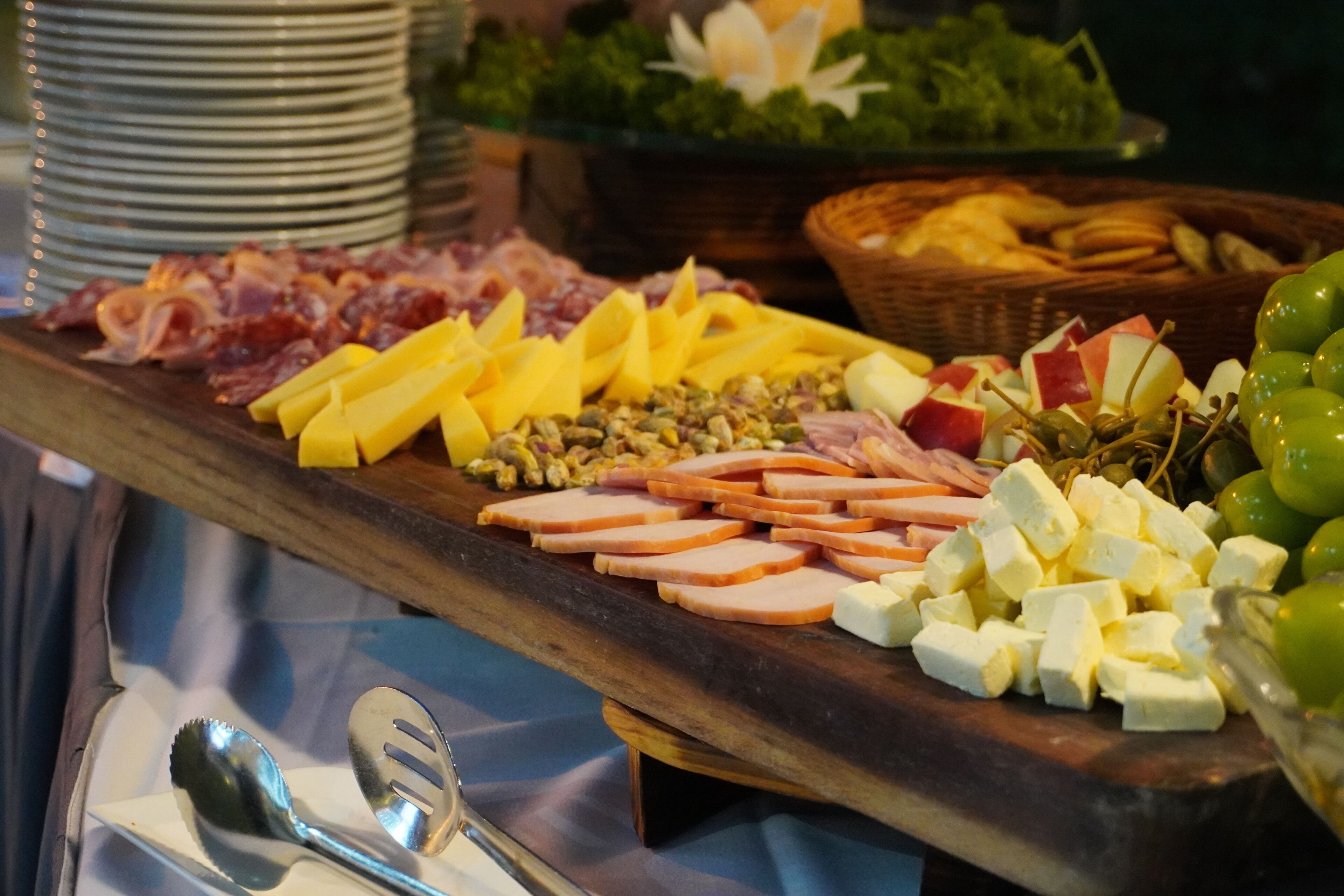 Ein Holzbrett mit verschiedenen Käsesorten, Fleisch und Obst.