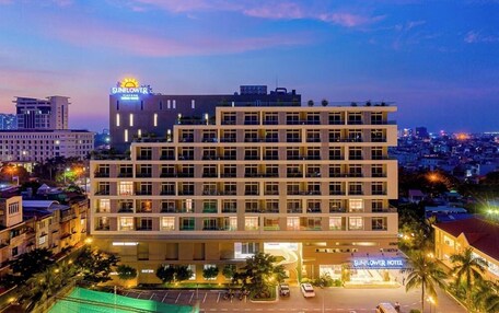 A multi-story hotel with a modern design, featuring a prominent sign for the Sunflower Hotel.
