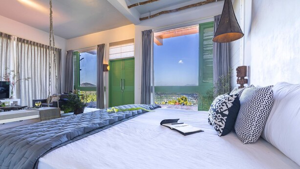 A modern bedroom with a large bed, a bedside table, a TV, and a balcony view. - Seclude Kasauli (Kasauli)