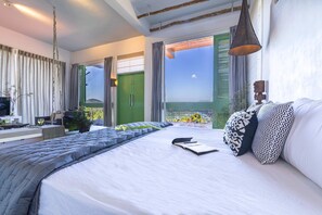 Une chambre moderne avec un grand lit, une table de chevet, une télévision et un balcon avec vue.