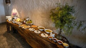A long wooden table with various dishes and a potted plant. - Seclude Kasauli (Kasauli)