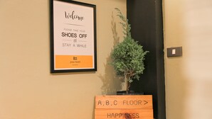 A welcome sign with a shoe-off policy and a sign indicating the A, B, C floor. - Jeune Hostel Chiang Mai (Chiang Mai)