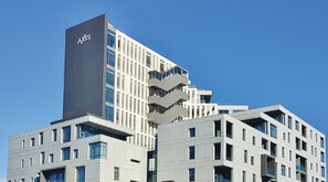 A modern building with a prominent 'AXIS' sign, multiple balconies, and a clear blue sky. - Axis Luxury Apartments  by Century City Hotels (Cape Town)