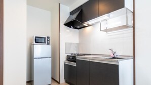 Une cuisine moderne équipée d’un four à micro-ondes encastré, d’un évier et d’une cuisinière.