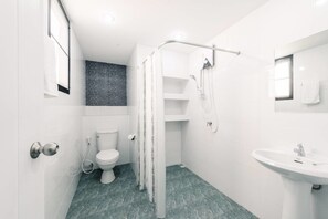 Et moderne badeværelse med toilet, bruser og vask.