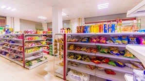 Un rayon d’épicerie où l’on trouve diverses collations et produits emballés, présentés sur des étagères.