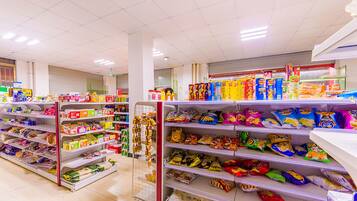 A grocery store aisle with various snacks and packaged goods on shelves.