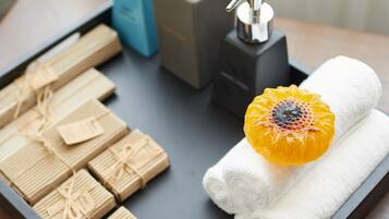 A tray with neatly arranged towels and a decorative orange flower, suggesting a spa or hotel setting.