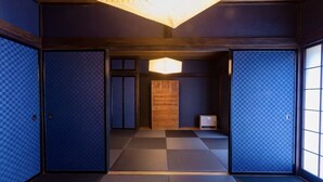 Ein traditioneller japanischer Raum mit Tatami-Boden, Shoji-Schirmwänden und einem zentralen Holzschrank.
