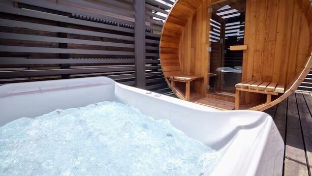 Ein Whirlpool mit Holzverkleidung und einer umlaufenden Holzterrasse.