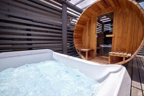 Uma banheira de hidromassagem com exterior de madeira e um deck de madeira ao redor.