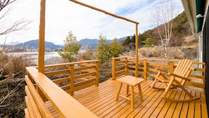 A wooden deck with a swing set and a rocking chair, overlooking a mountainous landscape. - tocoro. Mt. Fuji Mutsuki (Fujikawaguchiko)