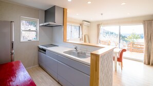 A modern kitchen with a built-in dishwasher, a large sink, and a window above the counter. - tocoro. Mt. Fuji Mutsuki (Fujikawaguchiko)