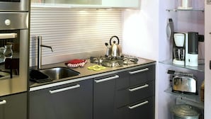 A modern kitchen with stainless steel appliances, a built-in oven, and a coffee maker.