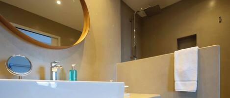 Un baño moderno con un espejo grande, un lavabo y un perchero para toallas.