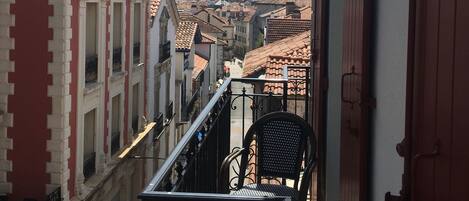A balcony with a view of a cityscape and mountains in the distance.