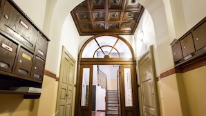 A hallway with wooden lockers, a decorative ceiling, and a staircase leading to another area. - Como Design Apartment (Como)