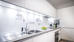 A modern kitchen with stainless steel appliances, a double sink, and a built-in oven. - Como Design Apartment (Como)
