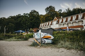 En strand med surfbrädor och en byggnad med ett rött tak.
