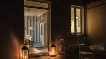A dimly lit room with a table and chairs, a window, and a door leading to another room.