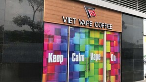 Een winkel met een kleurrijke etalage en de tekst 'VIET VAPE COFFEE'.