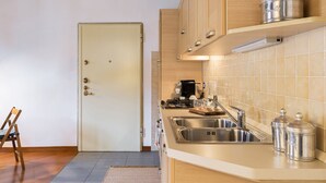 Une cuisine moderne avec des meubles en bois, un évier en acier inoxydable et une machine à café.