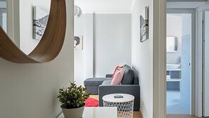 A modern living room with a sofa, a coffee table, and a potted plant. - Domus (Como)