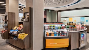 Een snackbar met diverse houdbare etenswaren en dranken, een koeltoog en een balie met een bord waarop staat 'Dit en dat en nog veel meer'.