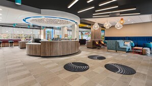 Een moderne lobby met een receptiebalie, zithoeken en een groot raam met uitzicht.