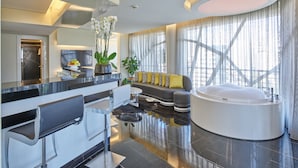A modern living room with a sofa, a coffee table, a round bathtub, and a large window with curtains. - Sodeco Suites (Beirut)