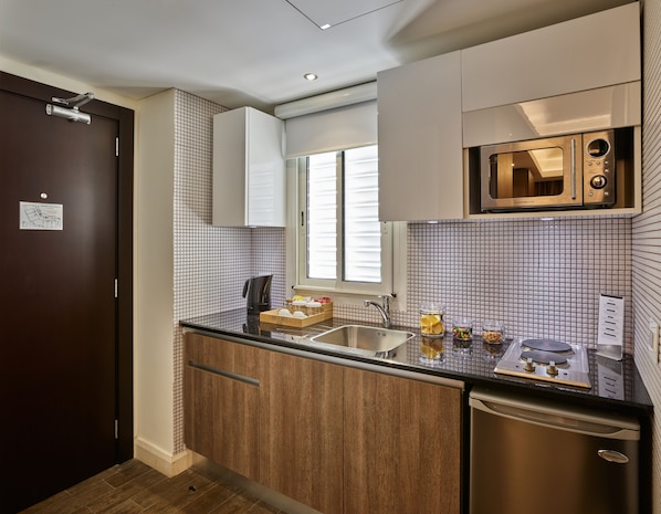 A compact kitchen with a microwave, sink, and a small dishwasher.
