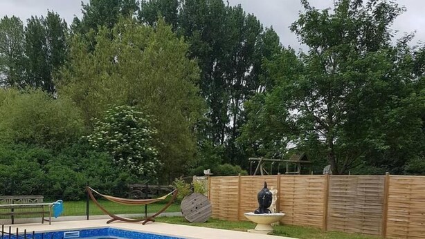 A rectangular swimming pool with a tiled edge, surrounded by a fence. - La Chaiserie (Romeries)