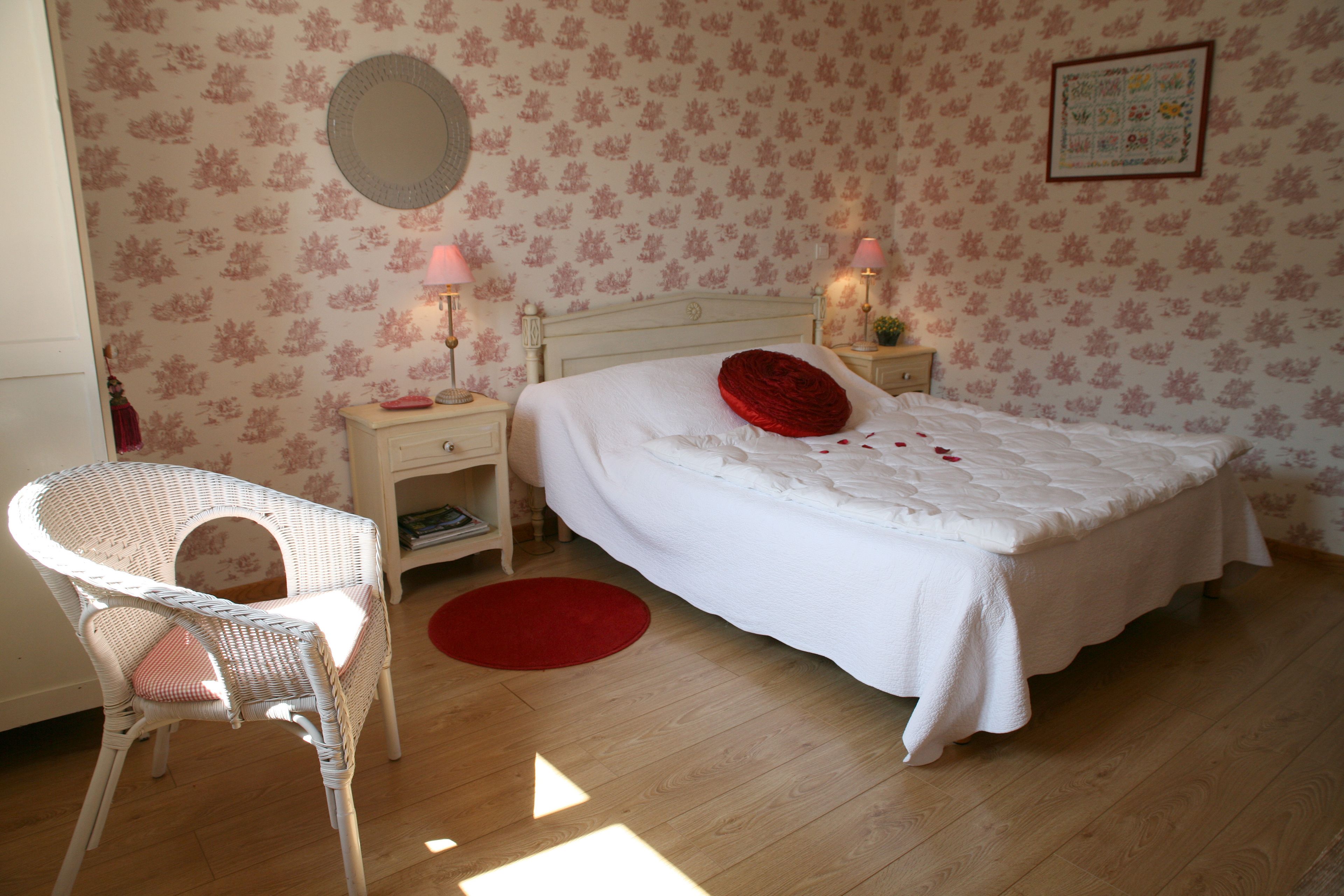 Une chambre à coucher comprenant un lit, une chaise, une table de chevet et une horloge murale.