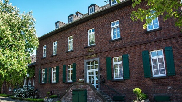 Ein traditionelles Backsteingebäude mit einem Schild, auf dem 