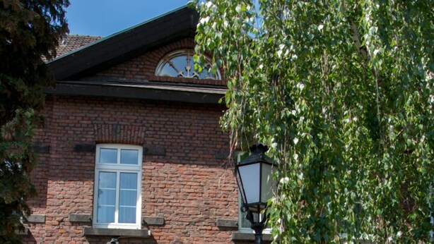 Un bâtiment traditionnel en briques, sur lequel on peut lire l’inscription « Gasthof Gus Keuchhof ».
