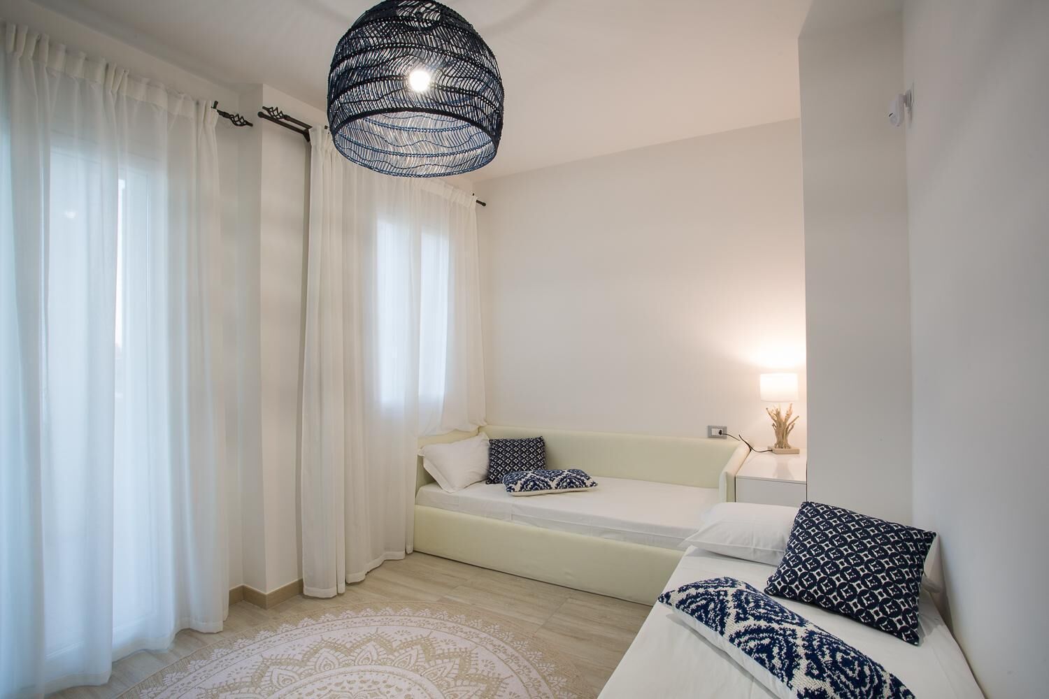 Ein modernes Schlafzimmer mit Bett, Nachttisch und einer Hängeleuchte.