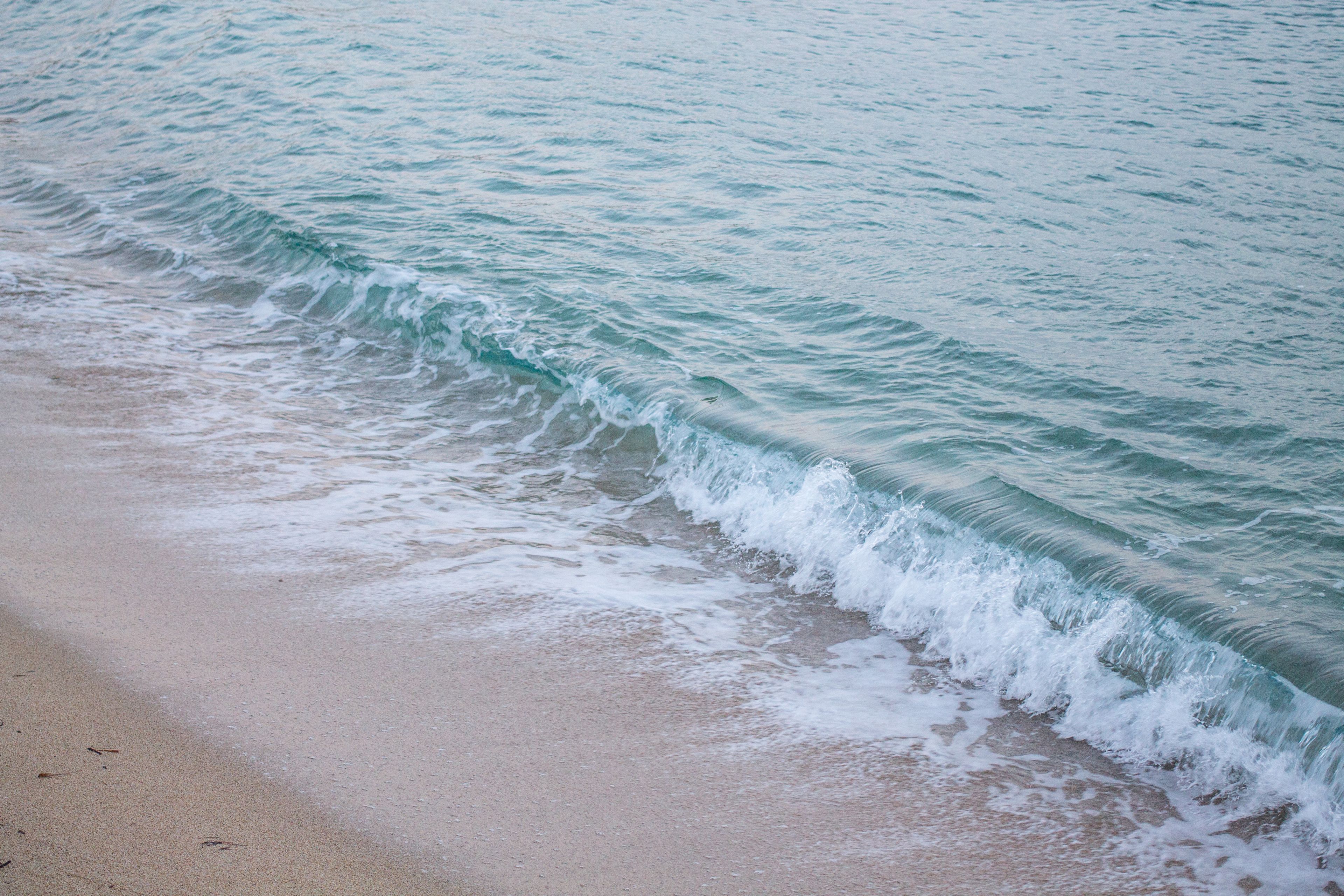 Ein Strand mit sanft anschwellenden Wellen.