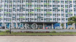 Un bâtiment moderne à la façade structurée, doté de grandes fenêtres et d’une entrée imposante sur laquelle est inscrit le mot « ENMRO ».