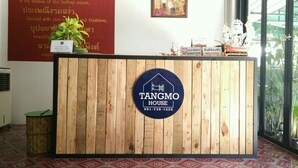 Un mostrador de recepción con acabado de madera, un cartel que dice 