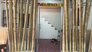 Una puerta con paneles de bambú, un piso estampado y una escalera que sube a un nivel superior.