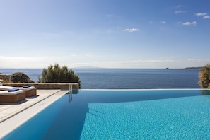 An infinity pool with a clear view of the sea and distant mountains. - AGL Luxury Villas (Mykonos)