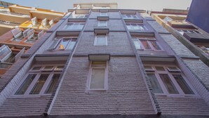 Ein mehrstöckiges Gebäude mit Backsteinfassade, zahlreichen Fenstern und Balkonen.